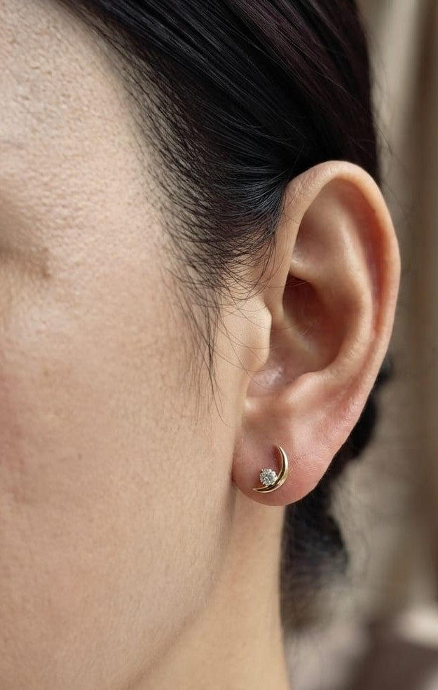18K yellow gold crescent moon stud earrings featuring 0.17 carat natural round brilliant diamonds with secure butterfly push backs.