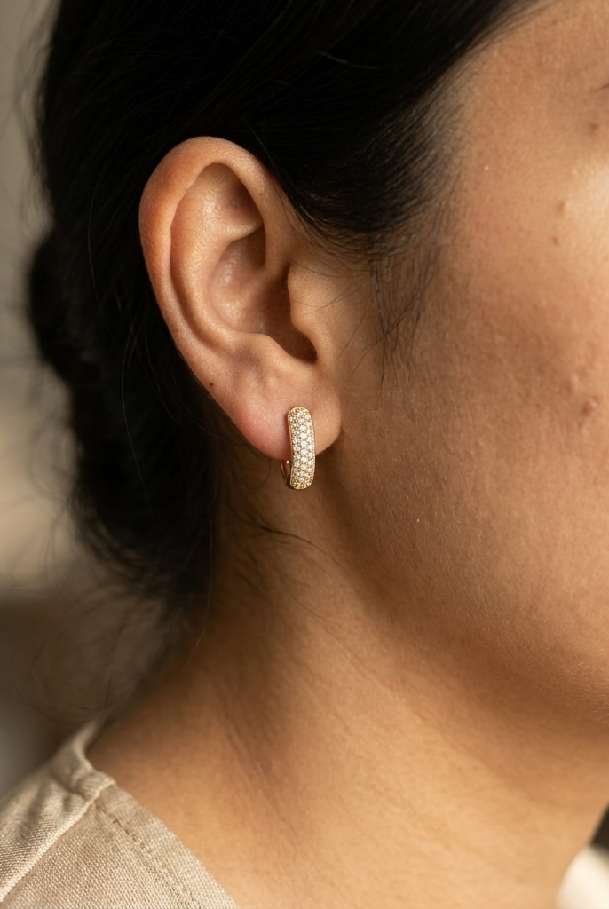 18K yellow gold diamond huggie hoop earrings featuring 0.51 carat natural round brilliant pavé-set diamonds with a secure hinged closure.