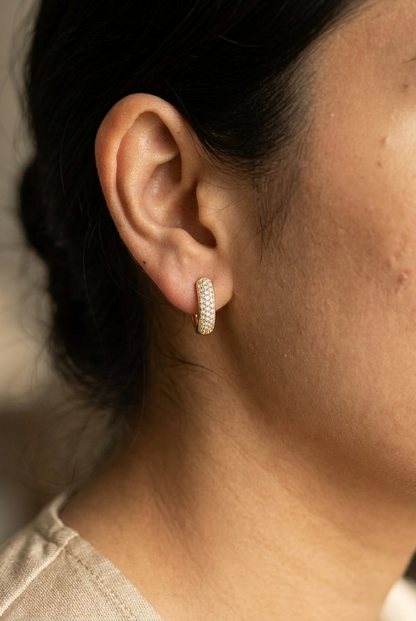 18K yellow gold diamond huggie hoop earrings featuring 0.51 carat natural round brilliant pavé-set diamonds with a secure hinged closure.