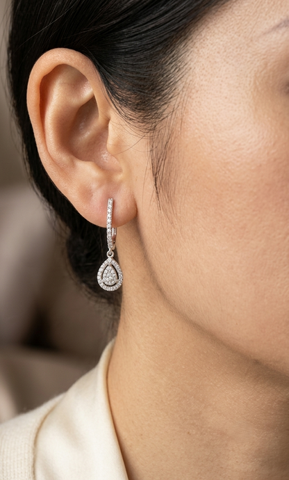 18K white gold pear diamond drop earrings featuring 0.44 carat natural diamonds with diamond-set huggie hoops and open pear halo design.