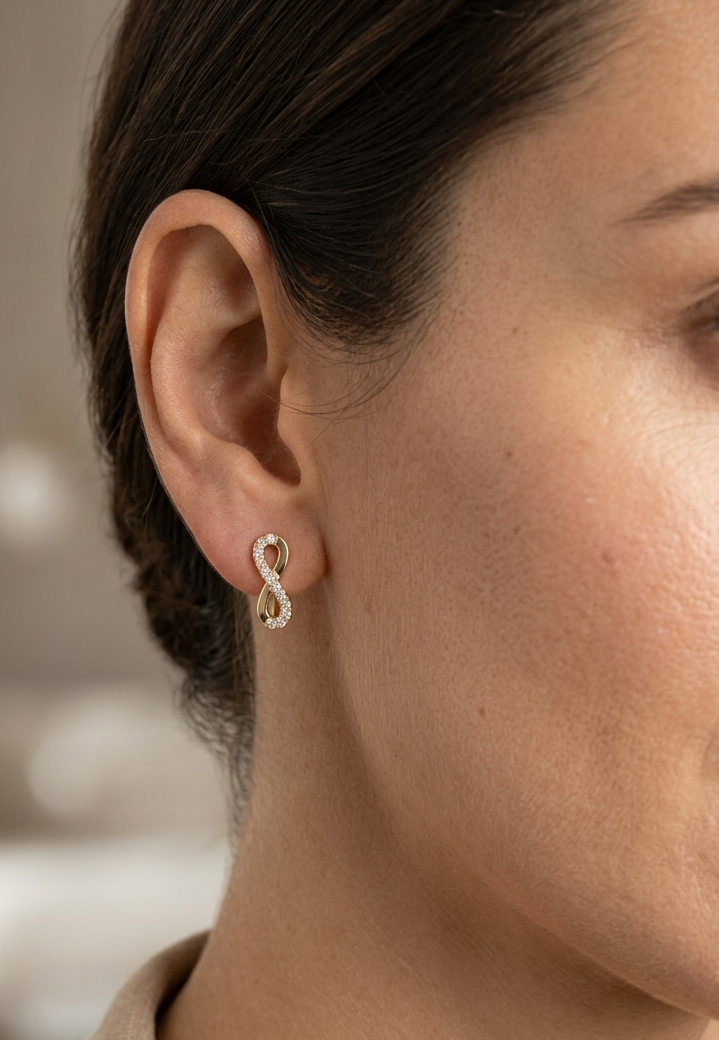 18K yellow gold infinity diamond earrings featuring natural round brilliant diamonds in a pavé setting with a total diamond weight of 0.22 carat.