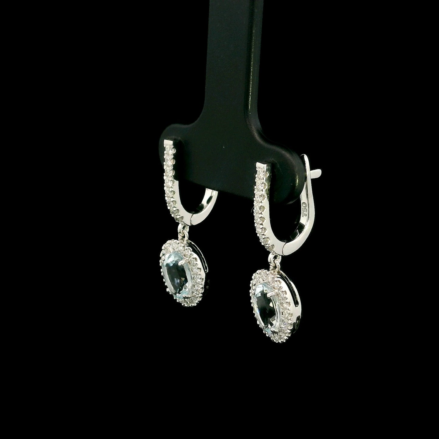 18K White Gold Aquamarine Drop Earrings featuring 1.50 carats of natural oval aquamarines surrounded by diamond halos with diamond huggie hoops and 0.48 carat natural diamonds.