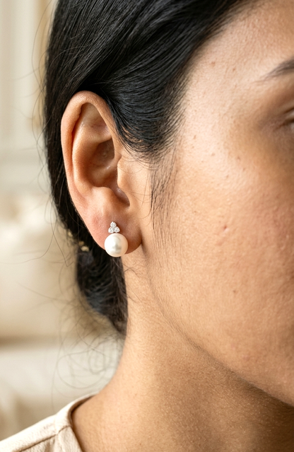18K white gold freshwater pearl stud earrings featuring 7.5 × 8 mm freshwater pearls with a natural round diamond three-stone cluster and secure butterfly backs.