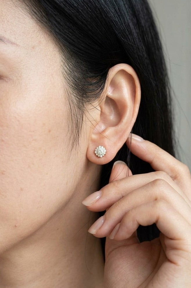Diamond halo stud earrings in 18K yellow gold with round centre diamonds surrounded by smaller round diamonds.