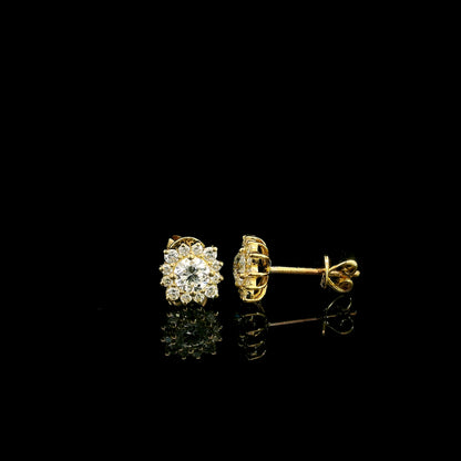 Diamond halo stud earrings in 18K yellow gold with round centre diamonds surrounded by smaller round diamonds.