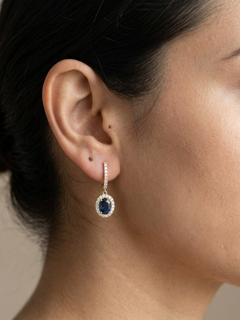 Oval blue sapphire and diamond halo drop earrings in 18K yellow gold with diamond-set hoops
