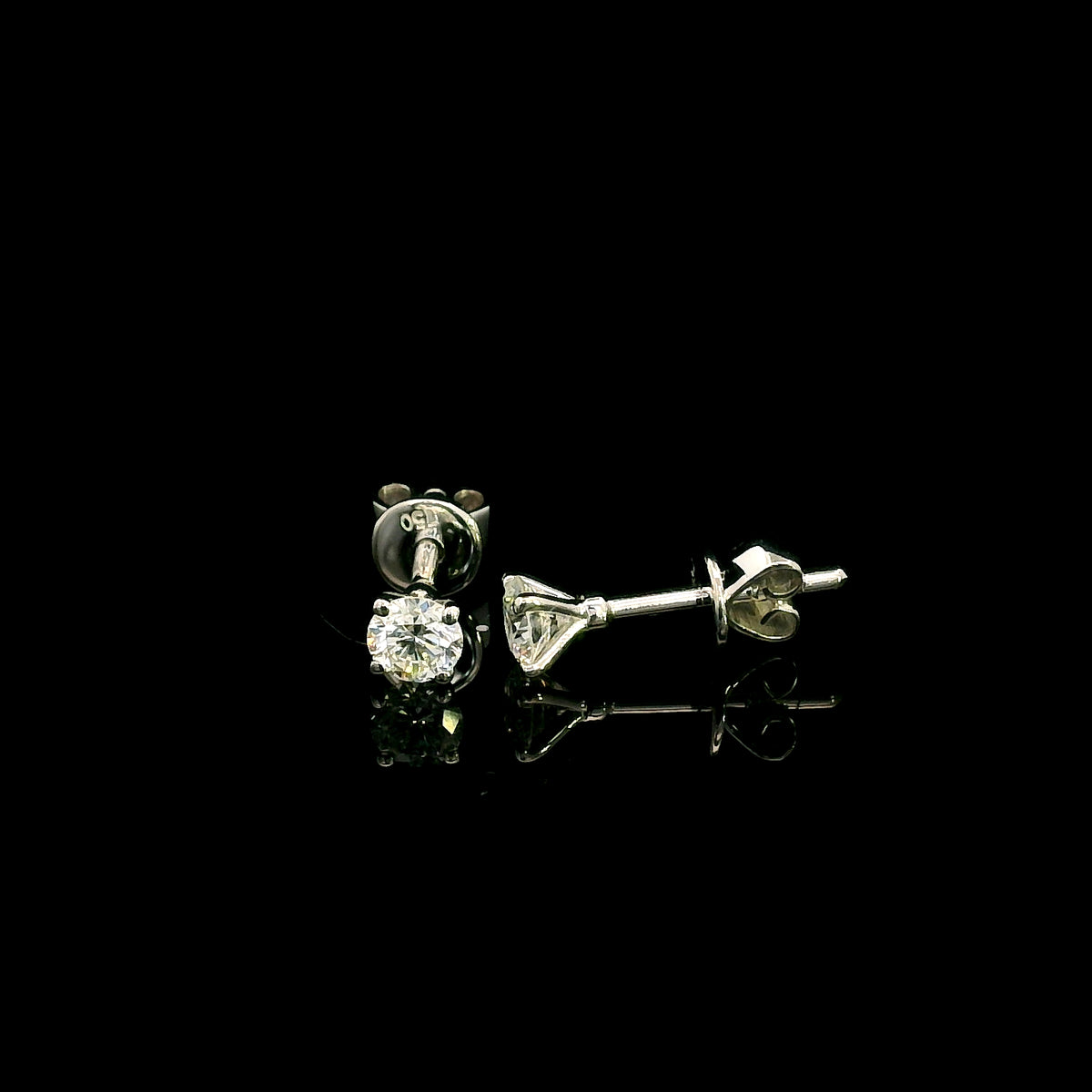 Diamond solitaire stud earrings in 18K white gold featuring round brilliant diamonds in classic four-prong settings.