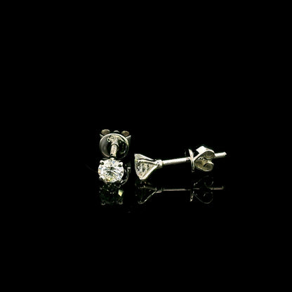 Diamond solitaire stud earrings in 18K white gold featuring round brilliant diamonds in classic four-prong settings.