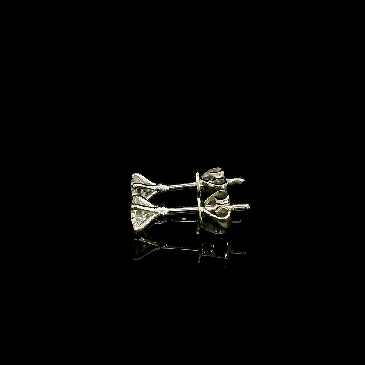 Diamond solitaire stud earrings in 18K white gold featuring round brilliant diamonds in classic four-prong settings.