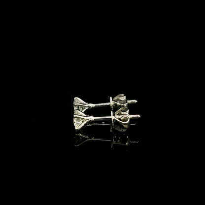 Diamond solitaire stud earrings in 18K white gold featuring round brilliant diamonds in classic four-prong settings.