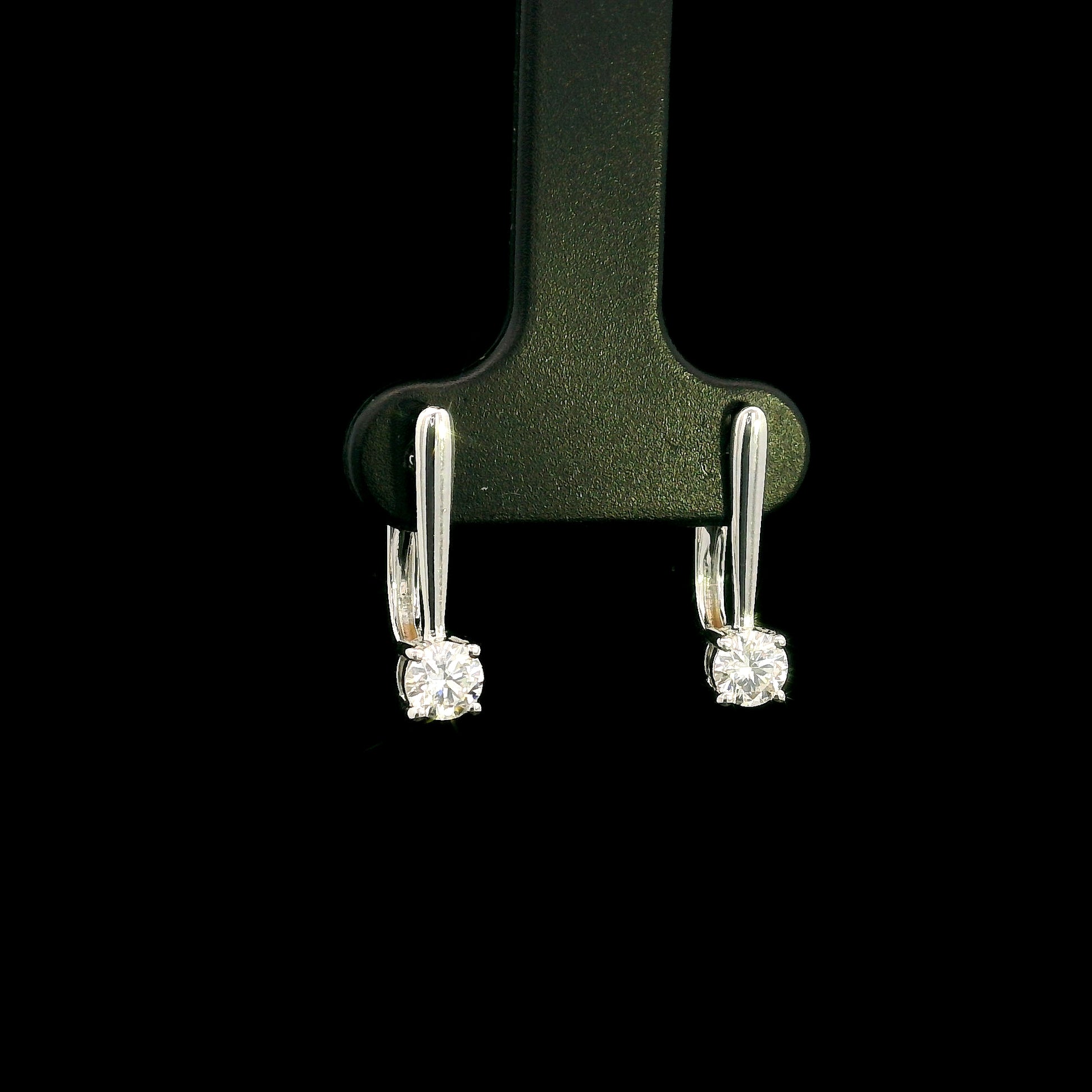 Round brilliant diamond drop earrings in 18K white gold featuring single four-prong set diamonds suspended beneath polished gold details.
