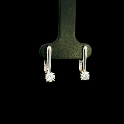 Round brilliant diamond drop earrings in 18K white gold featuring single four-prong set diamonds suspended beneath polished gold details.