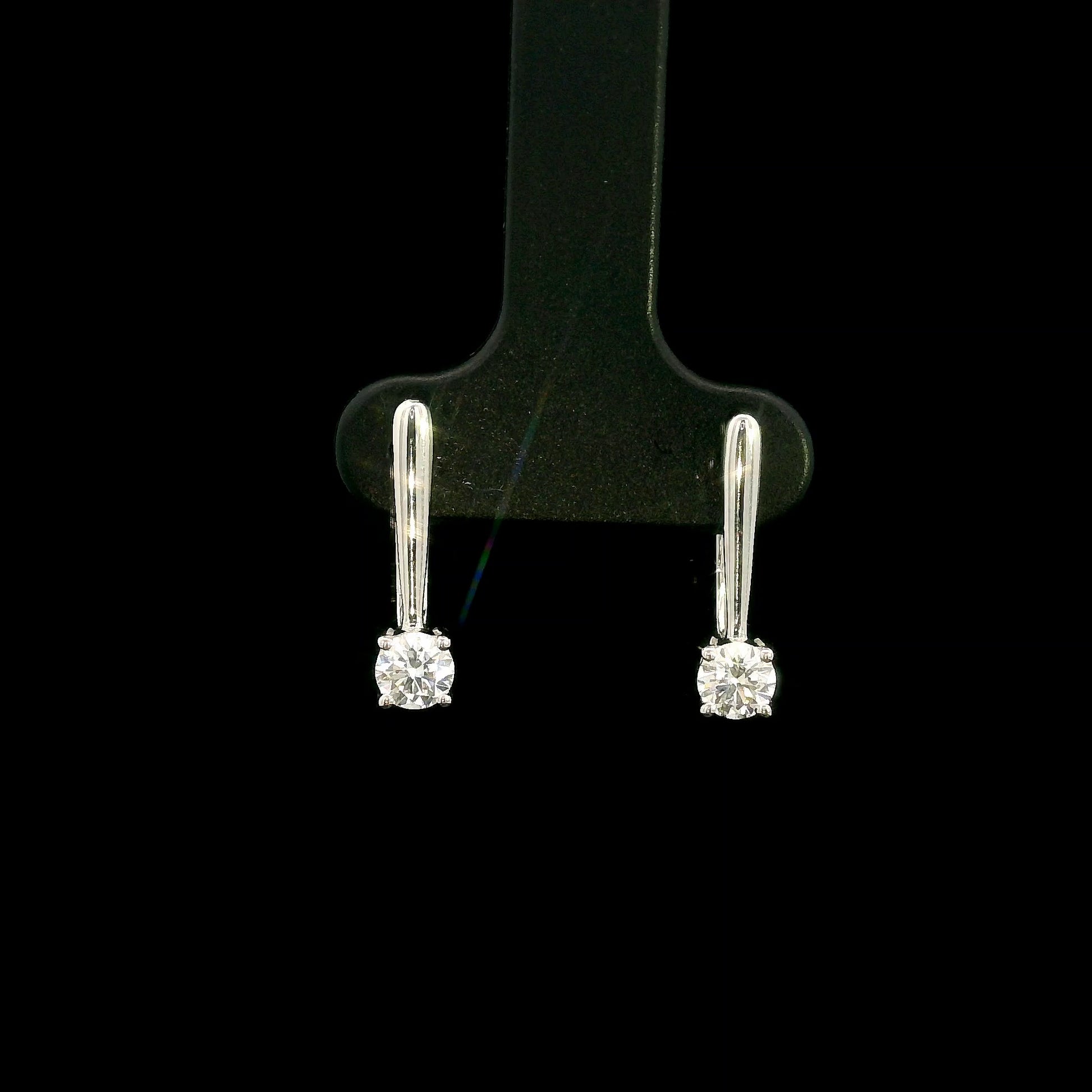 Round brilliant diamond drop earrings in 18K white gold featuring single four-prong set diamonds suspended beneath polished gold details.
