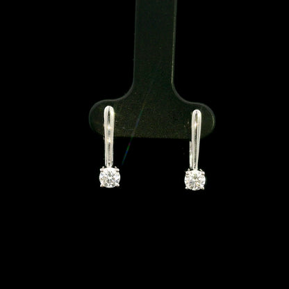 Round brilliant diamond drop earrings in 18K white gold featuring single four-prong set diamonds suspended beneath polished gold details.
