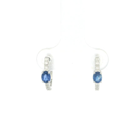 18K white gold blue sapphire and diamond huggie hoop earrings featuring oval blue sapphires and diamond-set hoops.