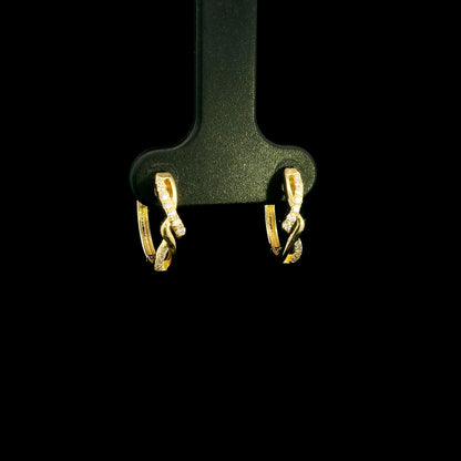 Diamond twist hoop earrings in 18K yellow gold with intertwined polished gold and round brilliant diamond details.