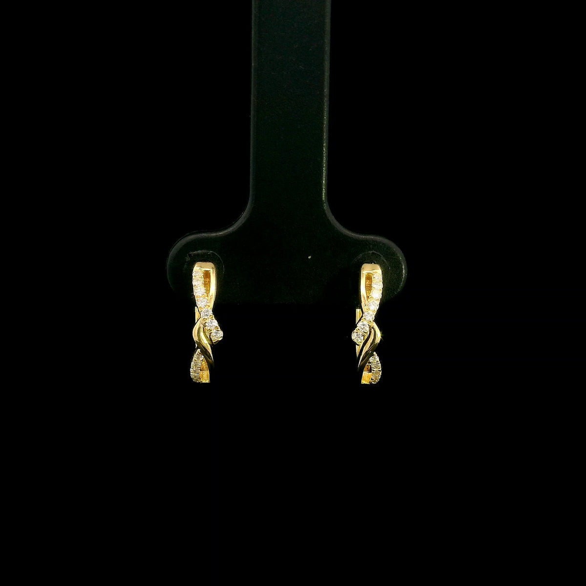 Diamond twist hoop earrings in 18K yellow gold with intertwined polished gold and round brilliant diamond details.