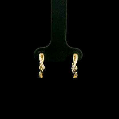 Diamond twist hoop earrings in 18K yellow gold with intertwined polished gold and round brilliant diamond details.