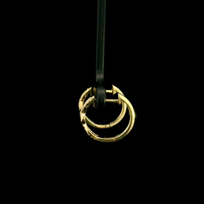 Diamond twist hoop earrings in 18K yellow gold with intertwined polished gold and round brilliant diamond details.
