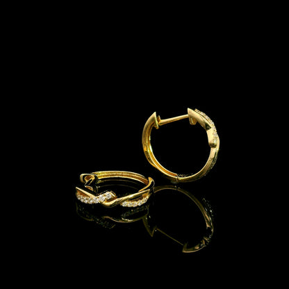 Diamond twist hoop earrings in 18K yellow gold with intertwined polished gold and round brilliant diamond details.