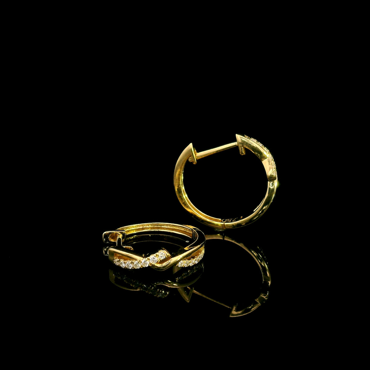 Diamond twist hoop earrings in 18K yellow gold with intertwined polished gold and round brilliant diamond details.