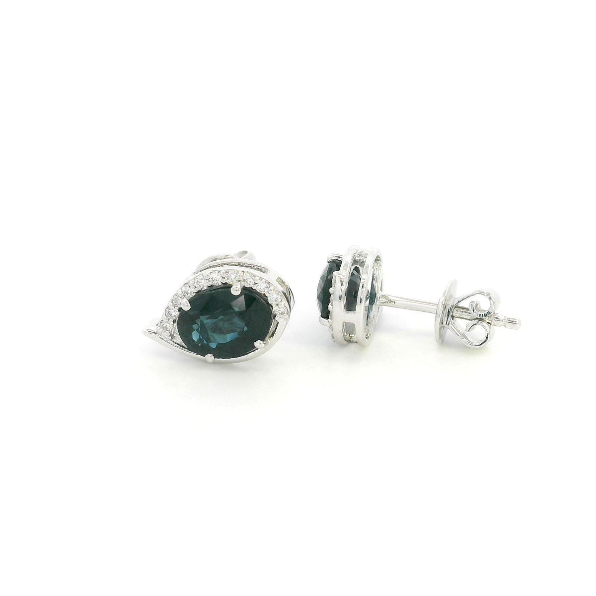 Oval blue sapphire and diamond stud earrings in 18K white gold with curved diamond accents