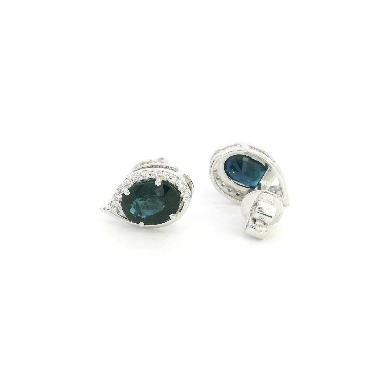 Oval blue sapphire and diamond stud earrings in 18K white gold with curved diamond accents