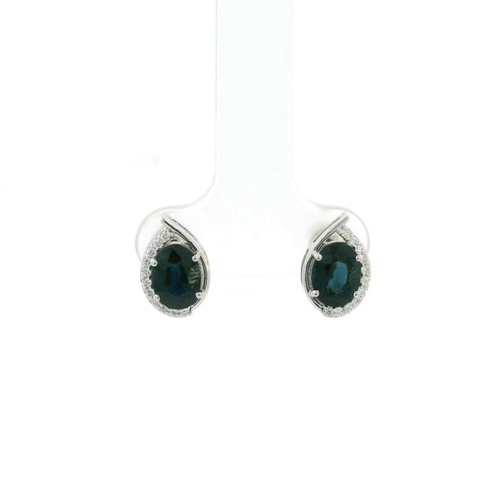 Oval blue sapphire and diamond stud earrings in 18K white gold with curved diamond accents