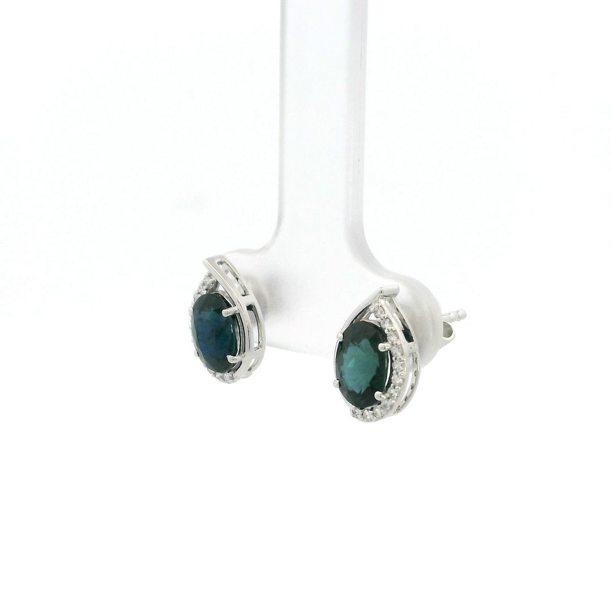 Oval blue sapphire and diamond stud earrings in 18K white gold with curved diamond accents