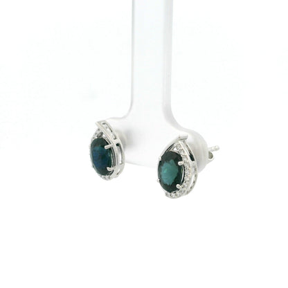 Oval blue sapphire and diamond stud earrings in 18K white gold with curved diamond accents