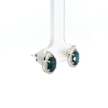 Oval blue sapphire and diamond stud earrings in 18K white gold with curved diamond accents