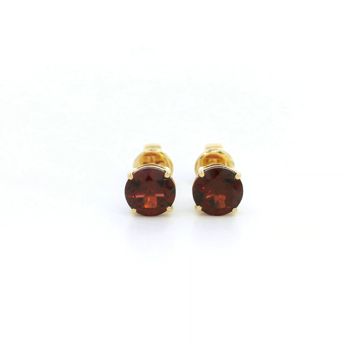 Round garnet solitaire stud earrings in 18K yellow gold with classic four-prong settings by Emirates Diamonds.