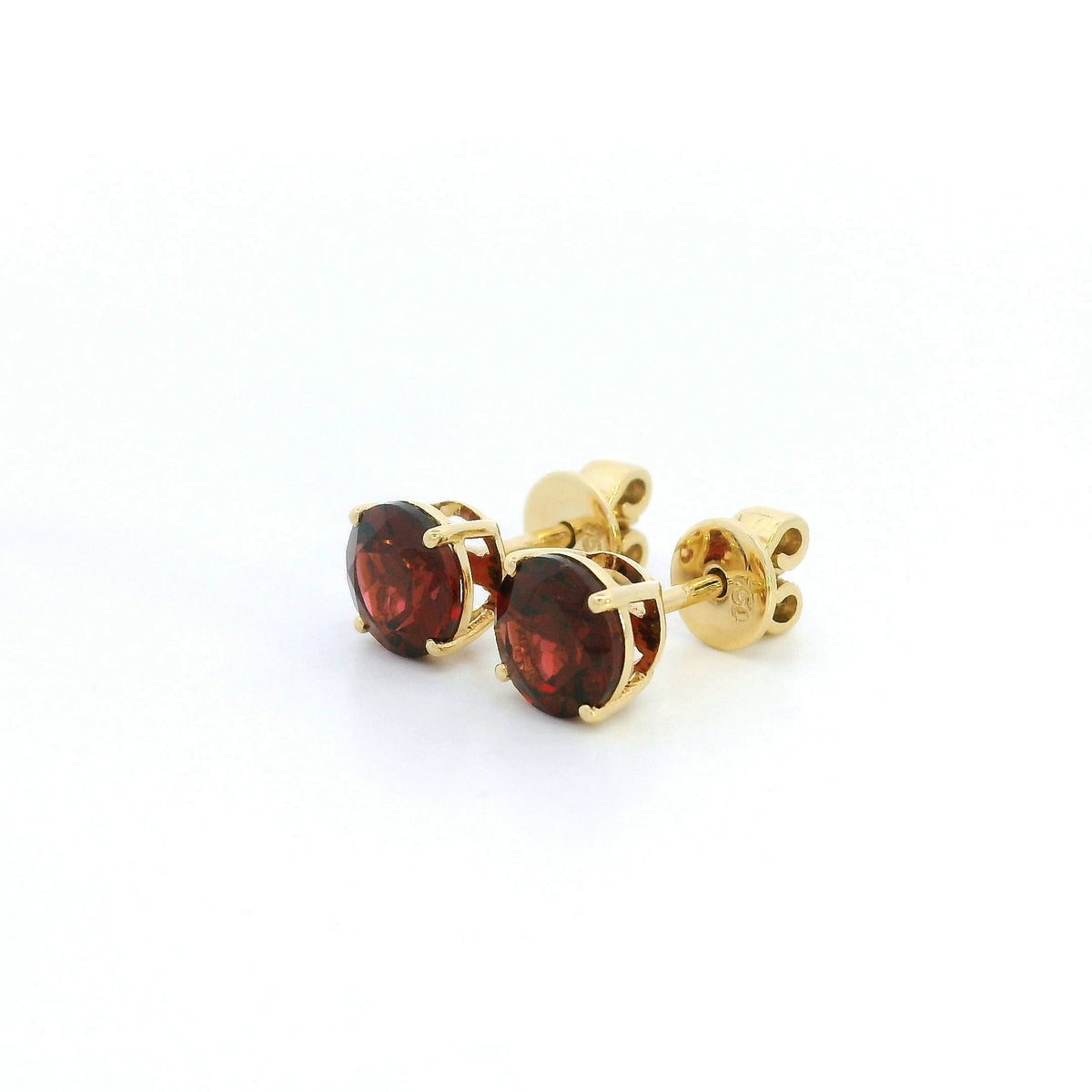 Round garnet solitaire stud earrings in 18K yellow gold with classic four-prong settings by Emirates Diamonds.