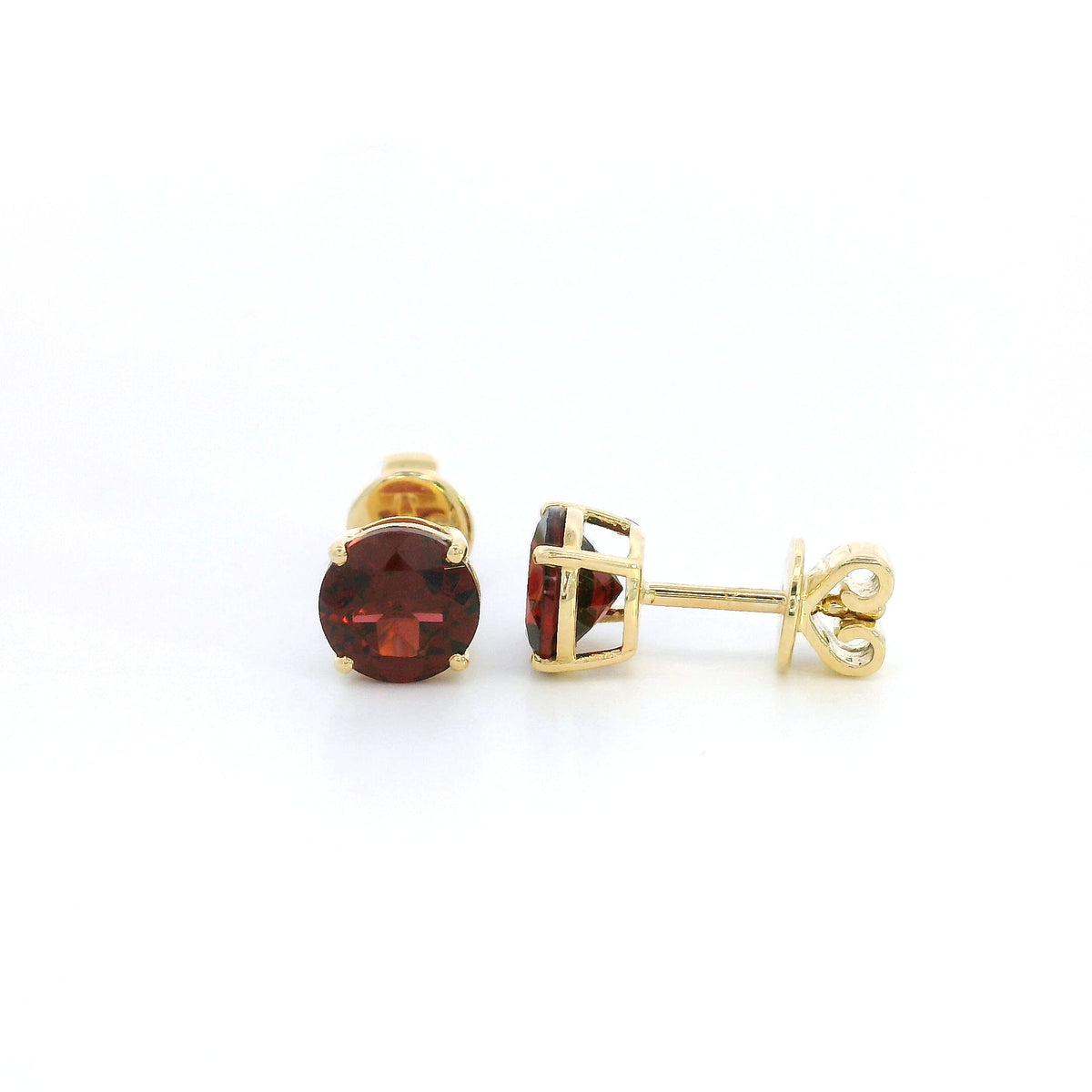 Round garnet solitaire stud earrings in 18K yellow gold with classic four-prong settings by Emirates Diamonds.