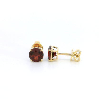 Round garnet solitaire stud earrings in 18K yellow gold with classic four-prong settings by Emirates Diamonds.