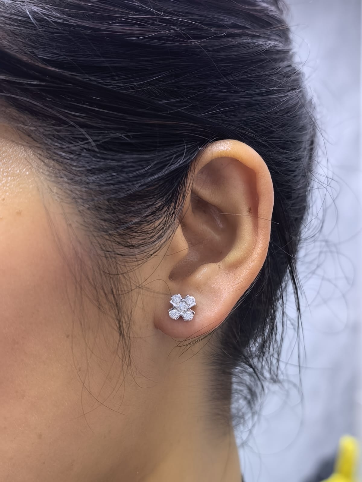 Four-petal diamond flower stud earrings in 18K white gold featuring round brilliant diamonds with minimal visible metal.