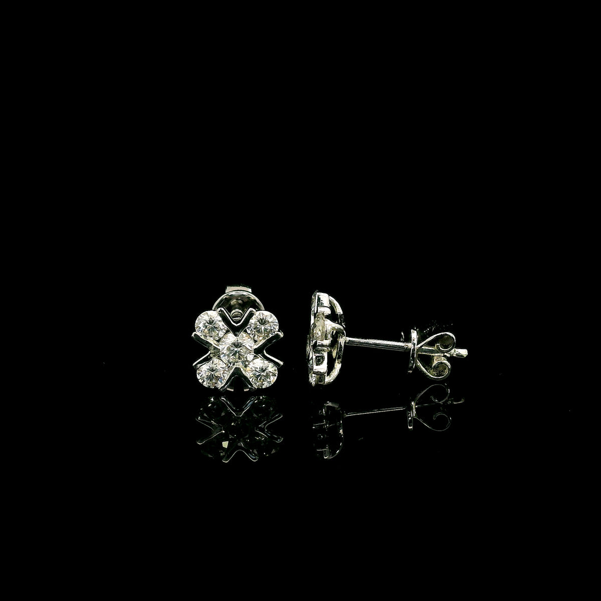 Four-petal diamond flower stud earrings in 18K white gold featuring round brilliant diamonds with minimal visible metal.