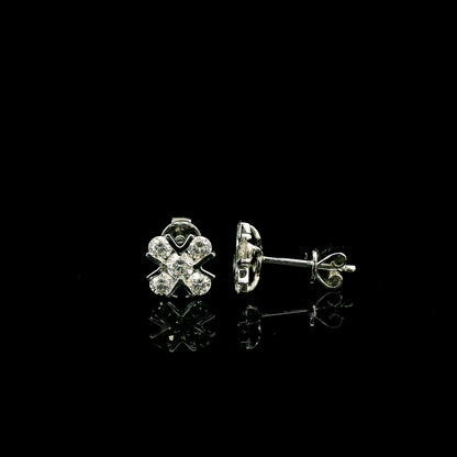 Four-petal diamond flower stud earrings in 18K white gold featuring round brilliant diamonds with minimal visible metal.