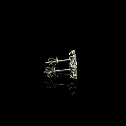 Four-petal diamond flower stud earrings in 18K white gold featuring round brilliant diamonds with minimal visible metal.