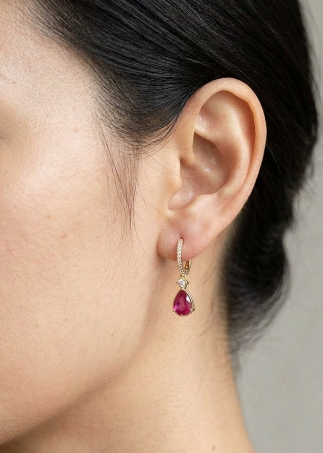 Pear-shaped ruby drop earrings with diamond-set huggie hoops in 18K yellow gold by Emirates Diamonds.