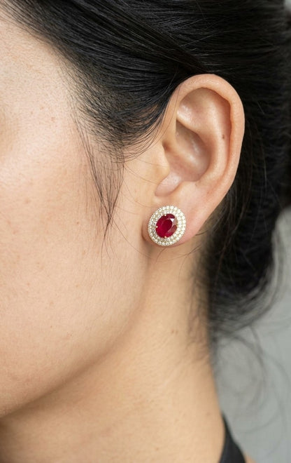 Oval ruby and double diamond halo stud earrings in 18K yellow gold by Emirates Diamonds.