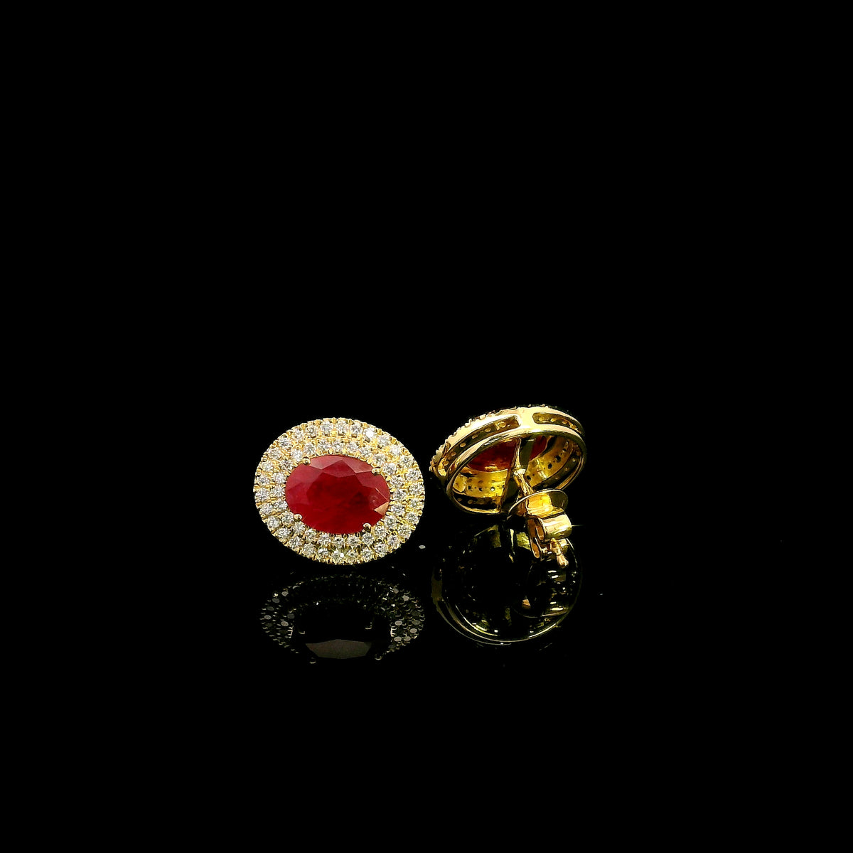 Oval ruby and double diamond halo stud earrings in 18K yellow gold by Emirates Diamonds.