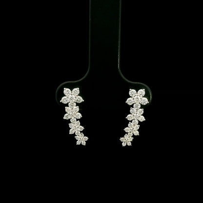 Diamond floral ear climber earrings in 18K white gold with graduating round diamond flower clusters designed to follow the ear.