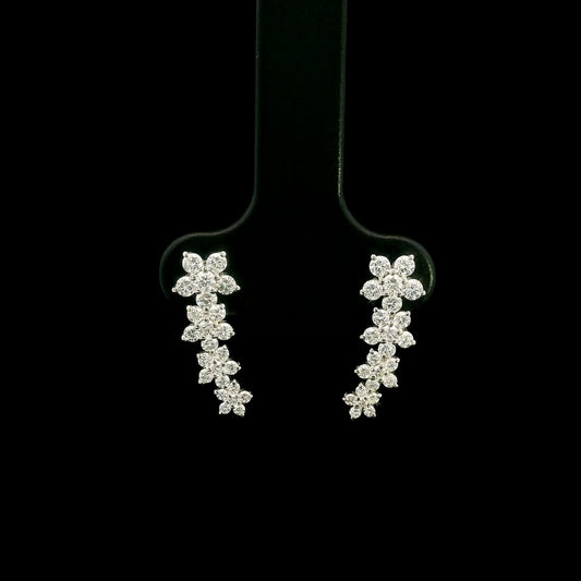Diamond floral ear climber earrings in 18K white gold with graduating round diamond flower clusters designed to follow the ear.