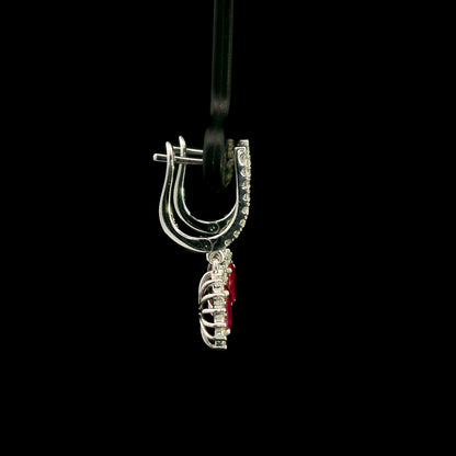 Ruby and diamond drop earrings in 18K white gold with oval ruby centres and diamond halos