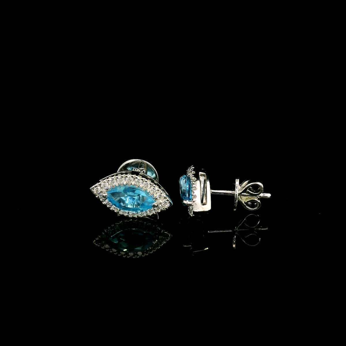 18K white gold blue topaz and diamond halo stud earrings featuring marquise-shaped blue topaz gemstones surrounded by round diamonds in an eye-shaped design.