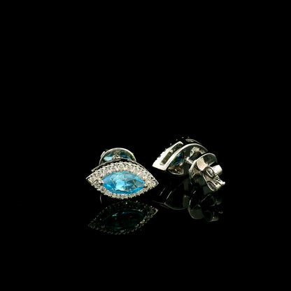 18K white gold blue topaz and diamond halo stud earrings featuring marquise-shaped blue topaz gemstones surrounded by round diamonds in an eye-shaped design.