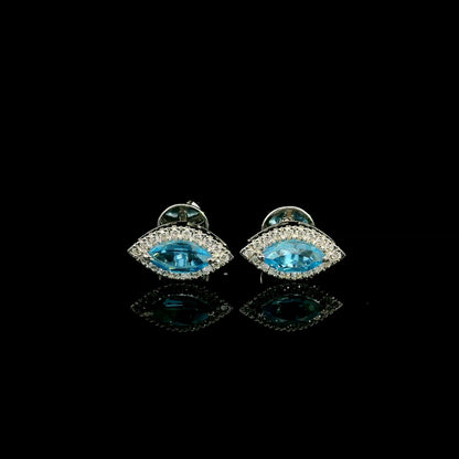 18K white gold blue topaz and diamond halo stud earrings featuring marquise-shaped blue topaz gemstones surrounded by round diamonds in an eye-shaped design.