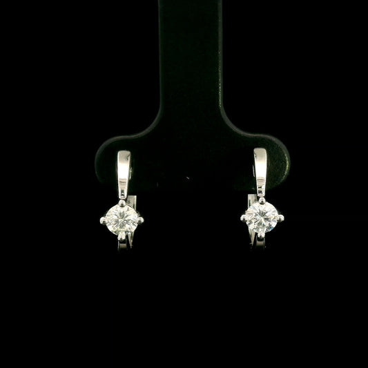 18K white gold huggie hoop earrings featuring a round diamond in a four-prong setting on each polished hoop.