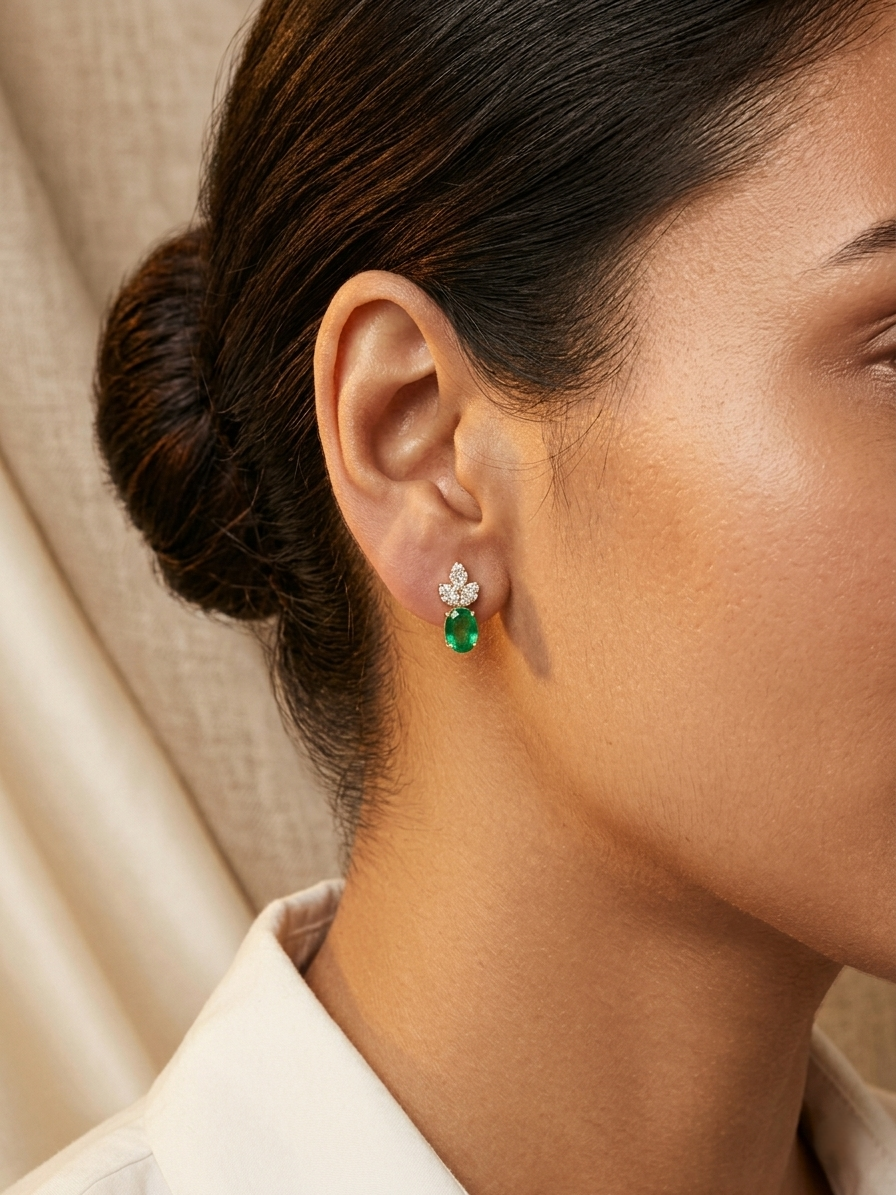 Emerald and diamond accent earrings in 18K yellow gold featuring 1.14 carat emeralds and 0.19 carat diamonds by Emirates Diamonds.